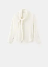 Blusa de modal y poliéster color blanco marfil, con diseño recto, escote en V, mangas largas y detalle de fular incorporado en el cuello. Cierre frontal con botones.