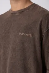 Remera de algodón gris con efecto acid wash, corte regular, mangas cortas y cuello redondo. Cuenta con un pequeño bordado tono sobre tono en el pecho y una etiqueta lateral distintiva de la marca en el ruedo.