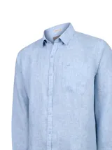 Camisa de lino manga larga color celeste, de corte clásico con cuello camisero, cierre frontal de botones y un bolsillo aplicado en el pecho.