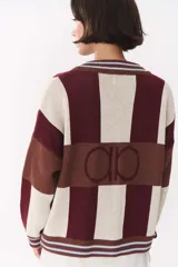 Cardigan de punto con diseño de bloques de color en tonos marrón, beige y verde. Presenta cuello redondo, cierre frontal con botones, mangas largas con hombros caídos y logo bordado en el frente.