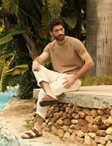 Remera de punto color beige, de manga corta y cuello redondo.