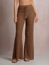 Pantalón de tiro alto con tejido calado y textura labrada, de corte recto con apertura acampanada hacia el ruedo. Cuenta con cintura elastizada y cordón de ajuste con terminaciones de caracoles decorativos.