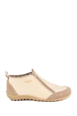 Zapato bajo de cuero color beige con refuerzos en gamuza en la puntera y el talón. Cuenta con doble cierre lateral diagonal, presilla trasera y suela de goma con relieve.