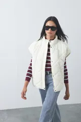 Chaleco acolchado de nylon con diseño capitoneado, cuello alto y cierre frontal con botones a presión. Presenta un calce amplio y versátil.