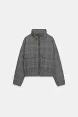Chaqueta estilo bomber con estampado de cuadros, cuello subido, manga larga y cierre frontal con cremallera. Presenta bolsillos delanteros y bajo elástico.