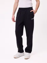 Pantalón tipo babucha de la marca Rusty, confeccionado en tejido de algodón y poliéster. Presenta un diseño liso en color negro, con cintura elástica y logo de la marca estampado en la parte frontal.