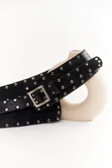 Cinto faja de cuero con estampado de vaca en blanco y negro, con hebilla metálica rectangular.