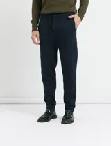 Pantalón jogging de tejido circular con cintura elástica y cordón ajustable. Presenta puños elastizados en el ruedo y bolsillos laterales.