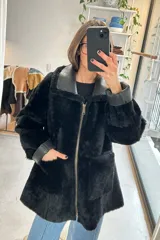 Campera reversible de cuero genuino napalán color negro, con cuello y detalles de corderito sintético, cierre frontal y bolsillos ribeteados.