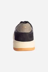 Zapatillas urbanas de cuero negro con detalles en gamuza, cordones negros y suela de goma color hueso.