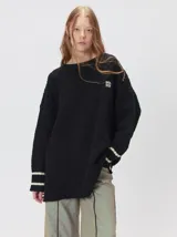 Sweater de punto con diseño de rombos en relieve, cuello redondo y calce holgado. Presenta aberturas laterales en el ruedo y logo bordado en el pecho.