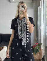 Conjunto de camisa de manga corta con cuello y pantalón largo de corte palazzo, ambos con estampado geométrico en blanco y negro.