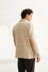 Saco sport marrón claro con medio forro, botones y coderas de cuero. Corte holgado, ideal para combinar con pantalón de vestir o jeans. Confeccionado en Uruguay con tela 100% lana fina sin teñir.