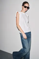 Jeans de tiro bajo, pierna ancha y largo completo, color negro. Presenta cinco bolsillos y cierre frontal con cremallera y botón metálico.