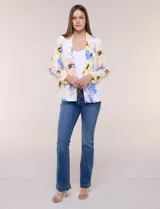 Blazer de silueta semientallada confeccionado en tela sastrera de color blanco con estampado floral en tonos amarillos, celestes, rosados y azules. Presenta solapa de muesca clásica, acceso frontal mediante un botón a tono, bolsillos simulados con solapa y mangas largas de corte clásico.