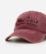 Gorra de algodón desteñido color bordó, con visera curva, estructura de paneles y bordado frontal en relieve con la inscripción "New York".