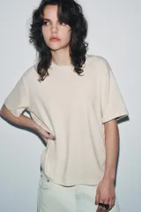 Camiseta de manga corta y cuello redondo, calce regular, color crema con textura jaspeada.