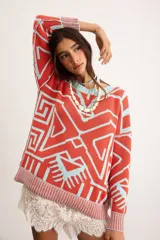 Buzo oversize de punto color marfil con diseño geométrico jacquard en tonos rosado, amarillo, celeste y marrón. Cuenta con cuello redondo y mangas largas.