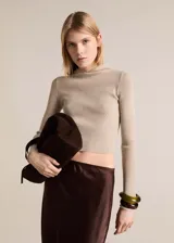 Jersey de punto canalé con diseño crop y ajuste slim fit. Presenta cuello alto con capucha integrada y manga larga.