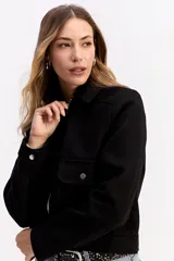 Campera corta de paño color negro, con cierre frontal metálico, cuello camisero y bolsillos frontales con solapa y botón metálico.