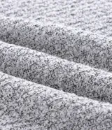 Suéter de punto texturizado color gris claro, con cuello polo y cierre frontal de botones. Presenta mangas largas con puños ajustados y un diseño de corte clásico.