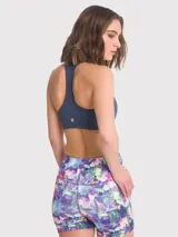 Top deportivo de color azul profundo, con diseño de espalda estilo nadador y sujetador integrado. Cuenta con almohadillas removibles y un calce regular.