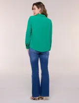 Blusa verde de calce holgado y caída fluida, confeccionada en tejido tipo crepé. Cuenta con cuello camisero con solapa, escote en V y cierre parcial al frente con tres botones metálicos. Las mangas son largas con puños abotonados.