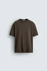 Camiseta de corte relajado confeccionada en tejido interlock de algodón con elasticidad, presenta cuello redondo y manga corta.