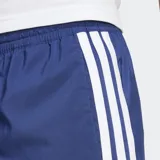 Shorts deportivos Adidas de color azul con las clásicas tres tiras blancas a los laterales y logo de la marca estampado en una pierna. Cuenta con cintura elástica con cordón ajustable.