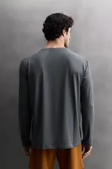 Camiseta de entrenamiento de manga larga y cuello redondo, confeccionada en tejido técnico ligero y elástico con tecnología de secado rápido. Presenta costuras planas para mayor resistencia y comodidad durante el movimiento, con un pequeño logo estampado en el bajo.