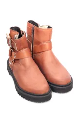Botin de cuero color bordo con suela track negra, cierre lateral, hebilla ajustable en la parte superior y detalle de correas con argollas metálicas en el tobillo.