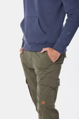Pantalón cargo azul marino con bolsillos laterales con solapa y cinturón de cuero marrón.