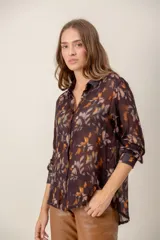 Camisa de manga larga con estampado de leopardo, cuello clásico y cierre frontal de botones. Presenta un corte holgado y puños abotonados.