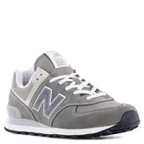 Championes urbanos New Balance modelo 574, color gris con detalles en blanco y gris claro. Confeccionados en una combinación de gamuza y tejido técnico, presentan el logo N característico en los laterales, entresuela ENCAP para mayor soporte y suela de goma con diseño inspirado en trail.