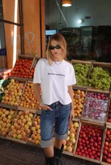 Remera blanca de manga corta con cuello redondo y texto estampado en negro en el pecho que dice "ME GUSTAS MUCHO. (ups)".