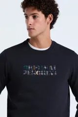 Buzo de cuello redondo en color azul marino, con estampado frontal que incluye el nombre de la marca con diseño a cuadros.