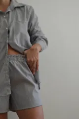 Short de tiro alto a rayas verticales azules y blancas, con cintura elastizada.