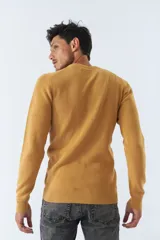 Sweater de punto color bordó, de corte clásico, cuello redondo y mangas largas. Presenta logo bordado en el pecho.