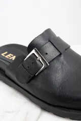 Zueco negro de cuero con hebilla metálica plateada ajustable y suela track.