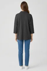 Camisa blanca de corte relajado, con cuello camisero, media cartera de botones y mangas 3/4.
