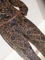 Conjunto de pijama con estampado animal print, compuesto por camisa de manga larga con botones y pantalón largo.