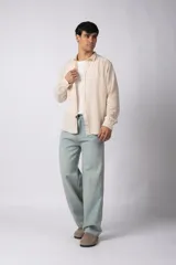 Camisa de lino blanca de manga larga, con cuello clásico y cierre frontal con botones. Corte recto y holgado.