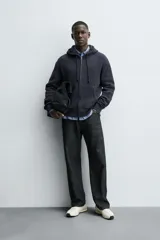 Sudadera hoodie relaxed fit color azul marino, confeccionada en tejido waffle con estructura cuadrillé. Cuenta con capucha ajustable, manga larga, bolsillos delanteros tipo canguro, acabados en rib y cierre frontal de cremallera. Presenta un efecto lavado.