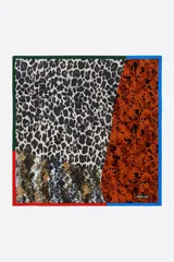 Pañuelo cuadrado de poliéster reciclado con diseño patchwork que combina estampados de animal print en tonos negro, marrón y tostado, con marcos contrastantes en rojo, azul y verde, y logo de la marca estampado.