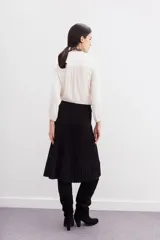 Falda midi tejida color negro, con diseño plisado y cintura elastizada.