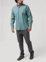 Camisa de manga larga color verde menta, confeccionada en popelina 100% algodón orgánico. Presenta cuello camisero, botones de madera, un bolsillo de parche en el pecho con logo bordado y presillas con botón en las mangas para sujetarlas enrolladas.