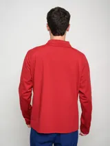 Buzo deportivo de polytraining color rojo, con medio cierre frontal y cuello alto. Presenta el logo de Umbro en el pecho izquierdo y el escudo del Club Nacional de Football en el pecho derecho.
