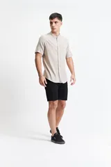 Camisa negra de manga corta con cuello mao y doblez en las mangas.