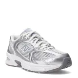 Championes New Balance 530 de estilo retro, color blanco con detalles plateados y grises, confeccionados en malla transpirable y material sintético, con la icónica letra "N" en el lateral y entresuela amortiguada.