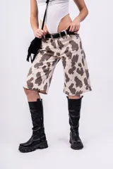 Bermuda de jean color beige con estampado de manchas marrones tipo vaca, tiro alto, corte ancho y largo a la rodilla.